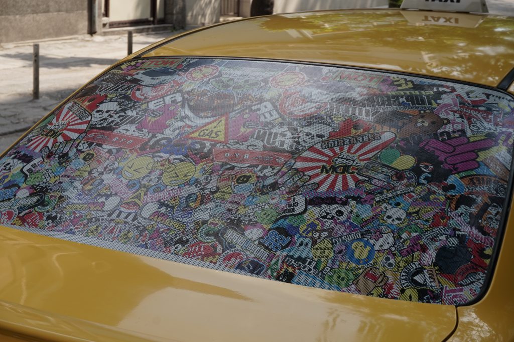 Back window of taxi covered with stickers