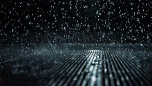 Macro photo of rain on a black surface during a night time